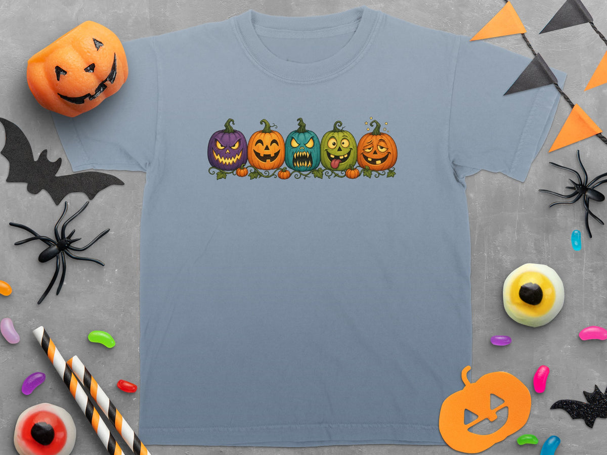 Light blue t-shirt with five cartoon pumpkins wearing Halloween costumes.