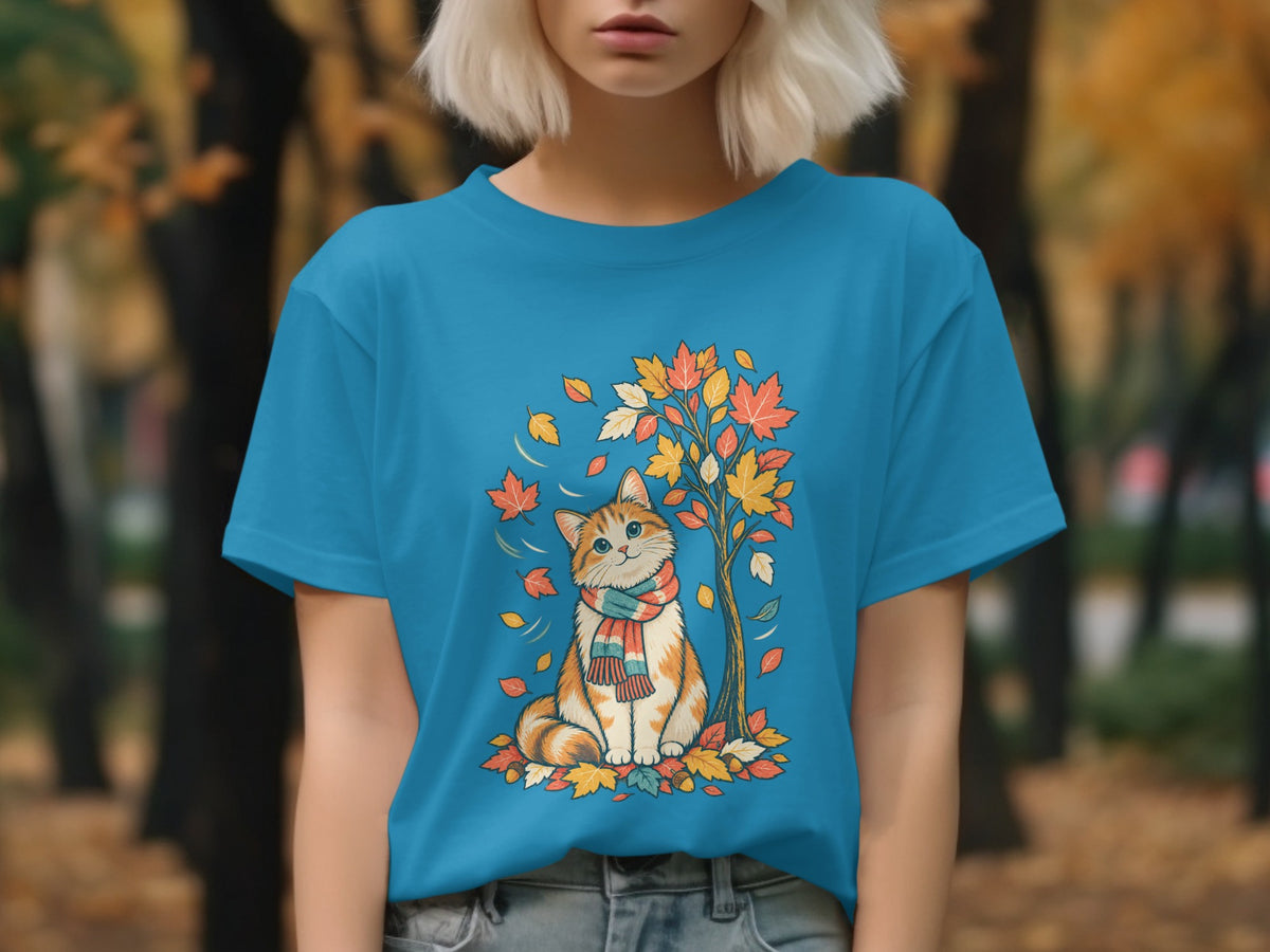 Orange and white cat in scarf sits by tree with colorful autumn leaves.