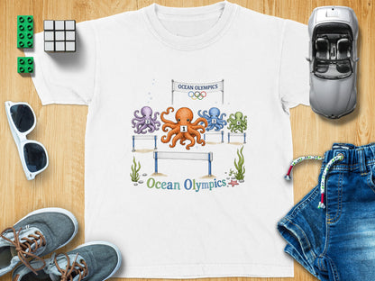 White t-shirt with four numbered octopuses racing under an "Ocean Olympics" banner.