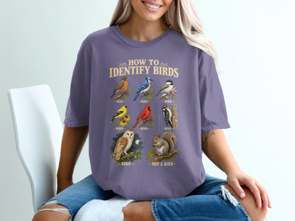 A person wearing a purple t-shirt featuring a funny vintage-style bird identification chart.
