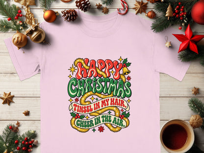 Pink t-shirt with "Happy Christmas" and "Tinsel in my hair, Cheer in the air" text.