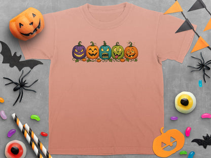 Peach t-shirt with cartoon pumpkins and Halloween decorations.