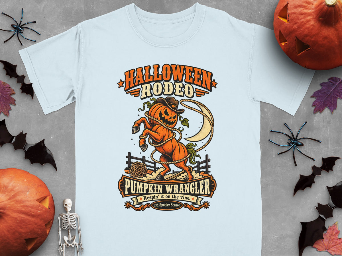 Light blue t-shirt featuring a pumpkin rodeo design with text "Halloween Rodeo" and "Pumpkin Wrangler".