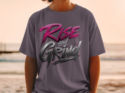 T-shirt with "Rise and Grind" text in metallic pink and grey brush strokes.