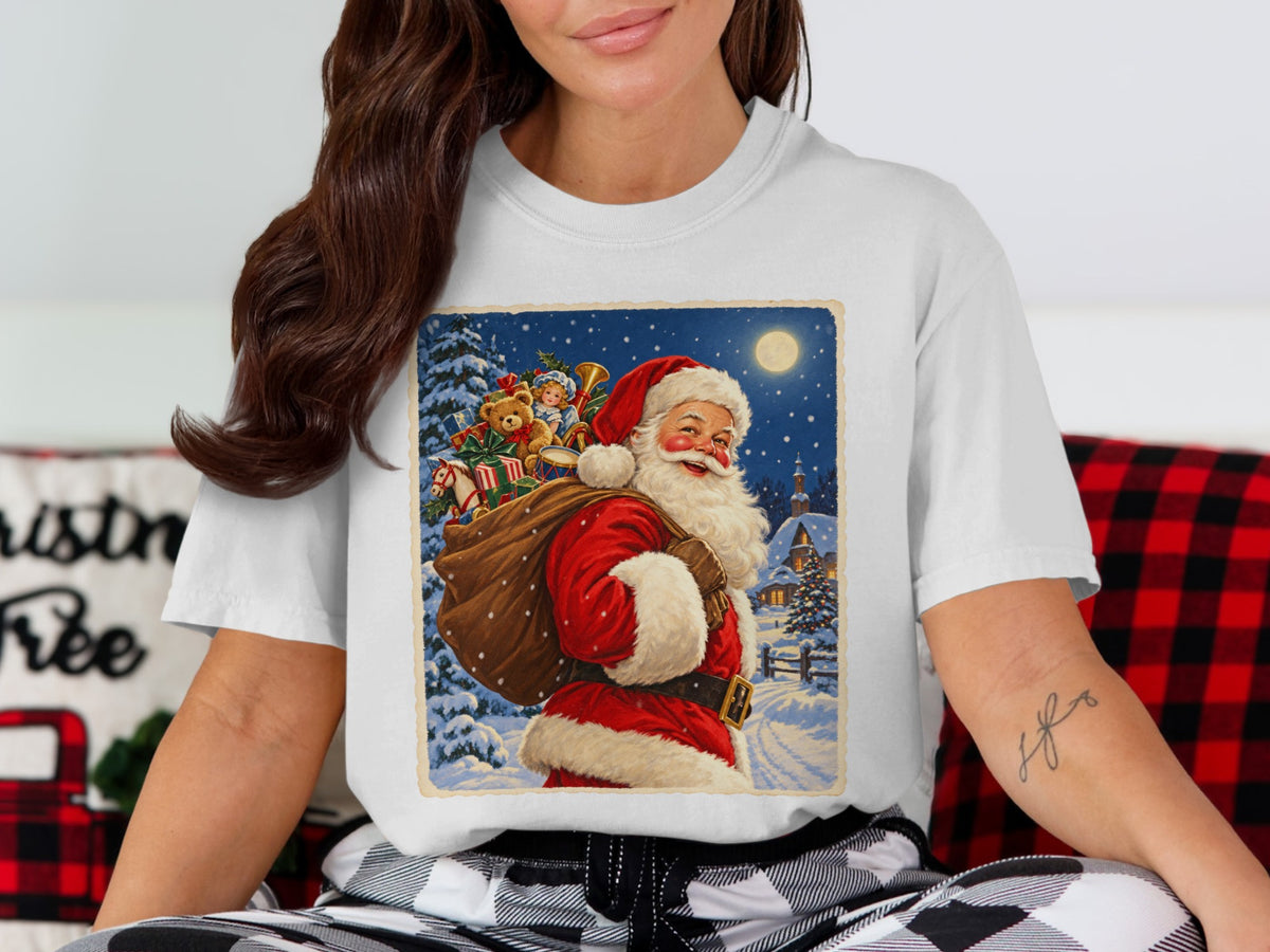 White t-shirt featuring vintage Santa Claus graphic with toy sack and snowy village.