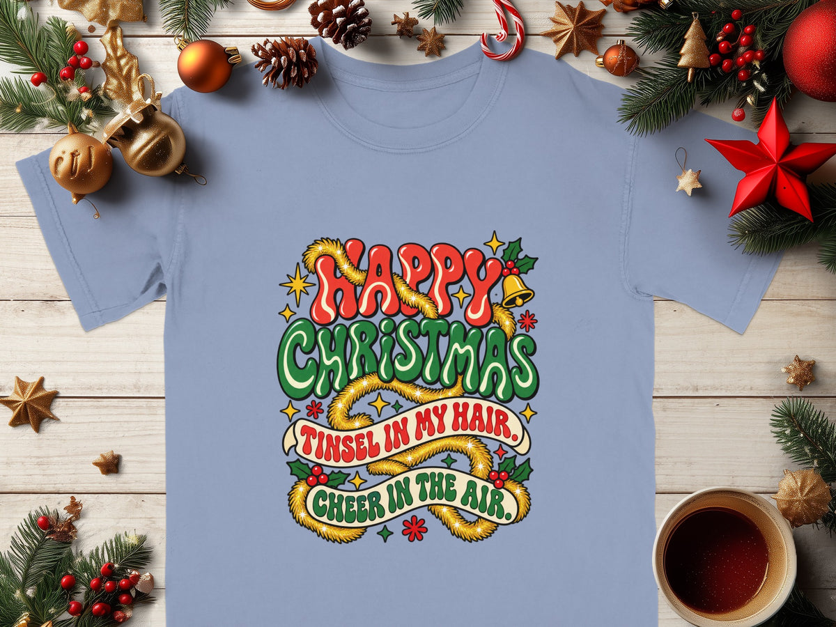 T-shirt with "Happy Christmas, Tinsel in my hair, Cheer in the air" text and festive decorations.
