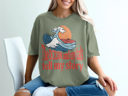Green t-shirt with vintage wave graphic and text: "The ocean and my tats tell my story."