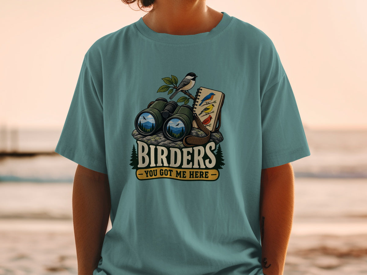 T-shirt graphic with binoculars, birds, and text "BIRDERS YOU GOT ME HERE".