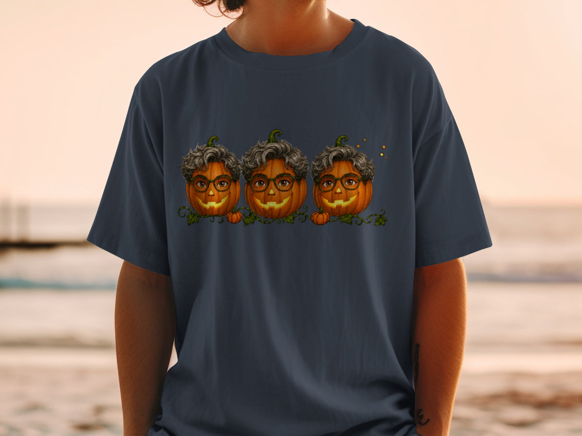 Three cartoon pumpkins with glasses and curly hair on a t-shirt.