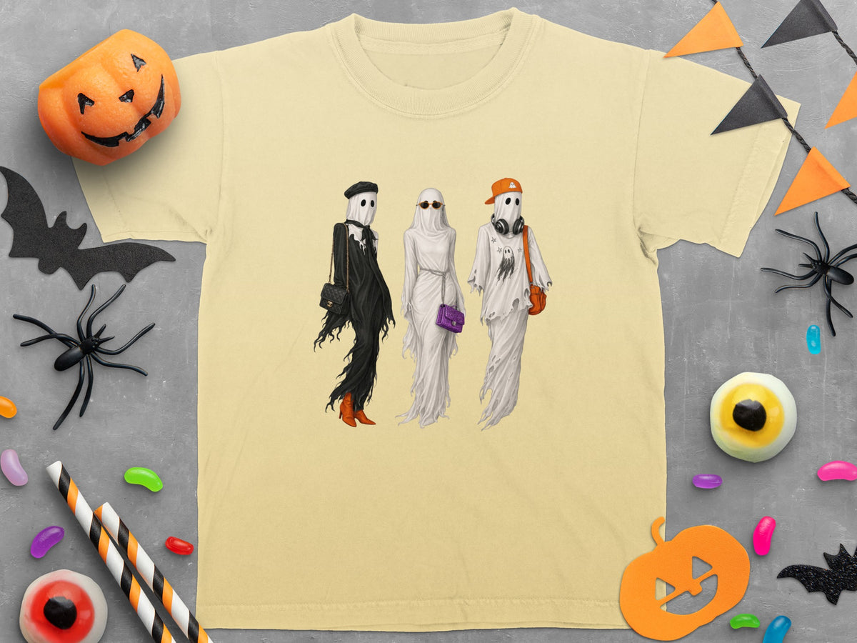 Three ghosts in fashionable outfits stand with Halloween decorations.