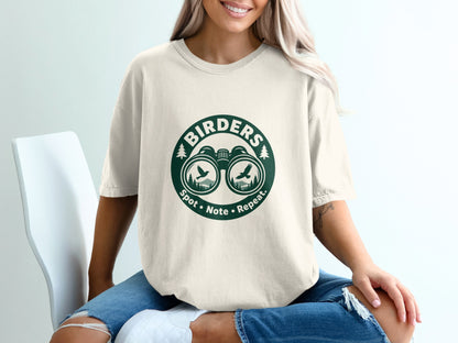 Cream t-shirt with green "Birders Spot Note Repeat" graphic featuring binoculars and birds.