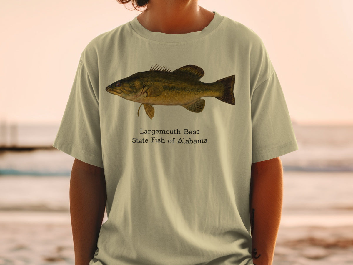 Largemouth Bass State Fish of Alabama graphic on a light tan t-shirt.