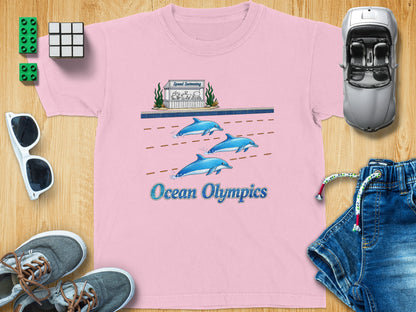 Pink t-shirt with "Ocean Olympics" and cartoon dolphins in a swimming race.