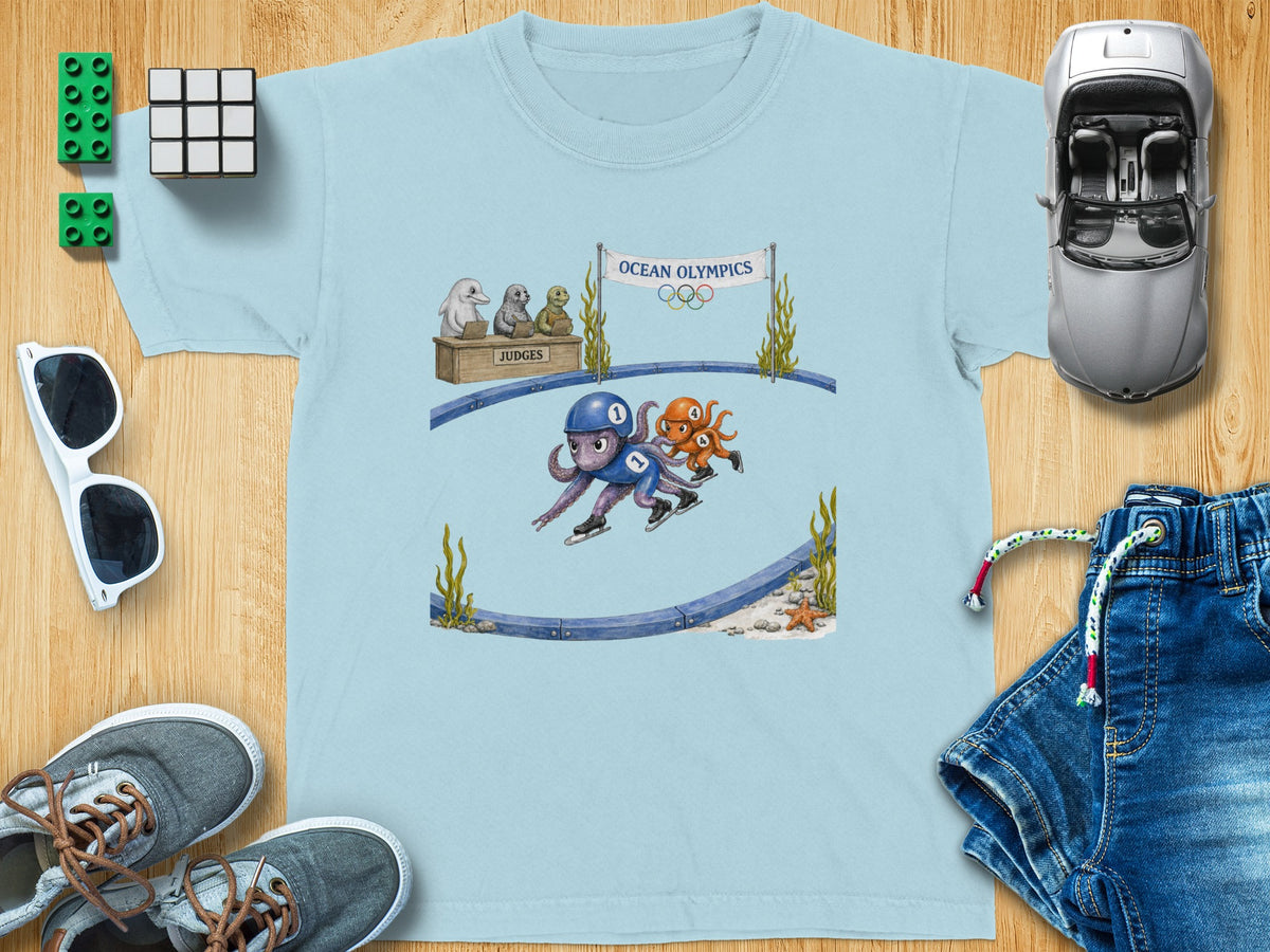 Light blue t-shirt with an "Ocean Olympics" graphic featuring octopuses ice skating and seal judges.