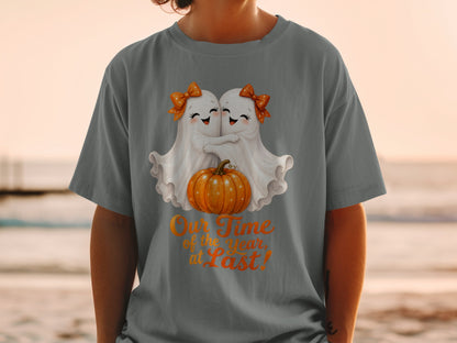 T-shirt with two ghosts hugging a pumpkin, text "Our Time of the Year, at Last!".