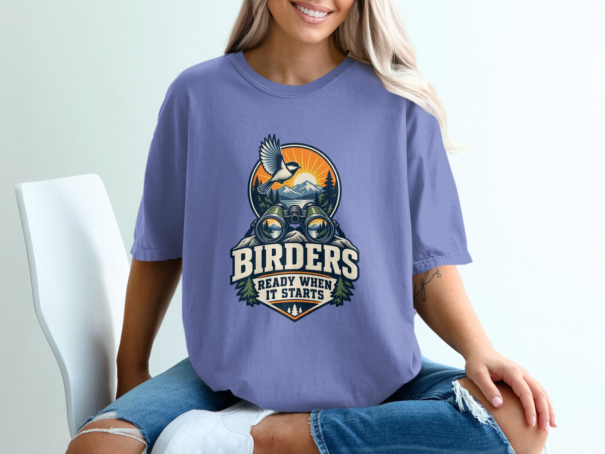 T-shirt graphic with binoculars, bird, mountains, and text "BIRDERS READY WHEN IT STARTS".