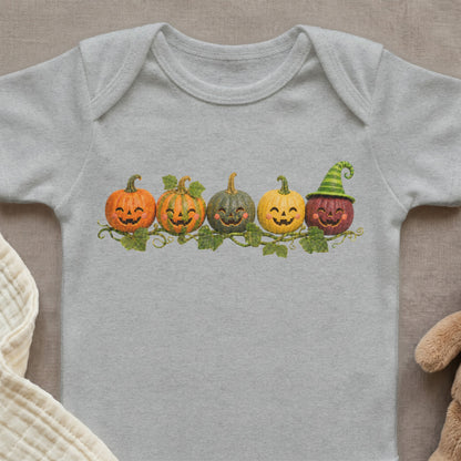 Five smiling cartoon pumpkins with vines and leaves on a grey baby bodysuit.