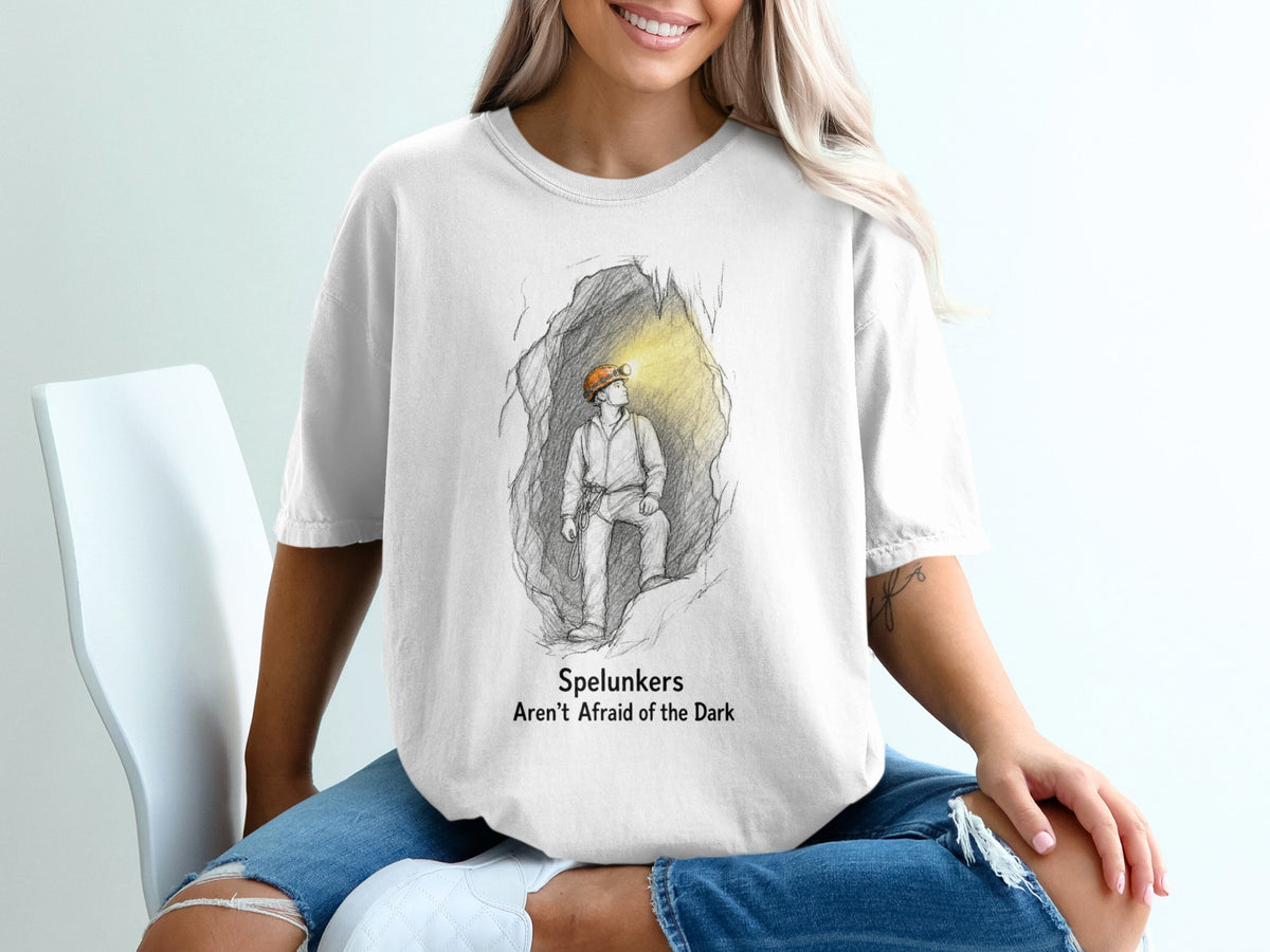 White t-shirt with graphic of spelunker in cave, text "Spelunkers Aren't Afraid of the Dark".