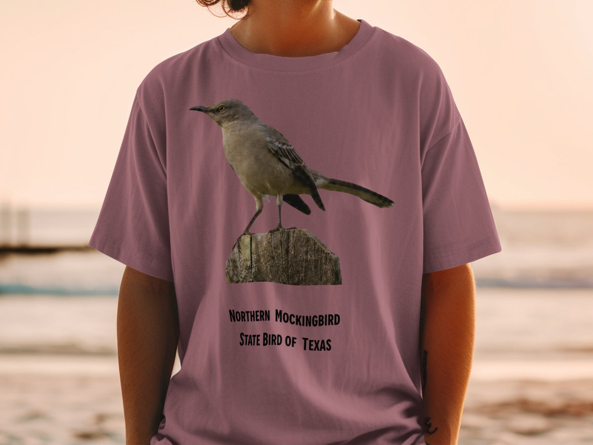 Northern Mockingbird, state bird of Texas graphic on a mauve t-shirt.