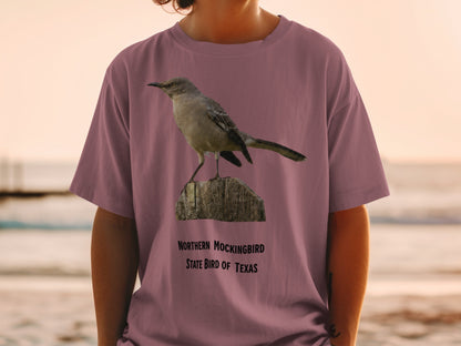 Northern Mockingbird, state bird of Texas graphic on a mauve t-shirt.