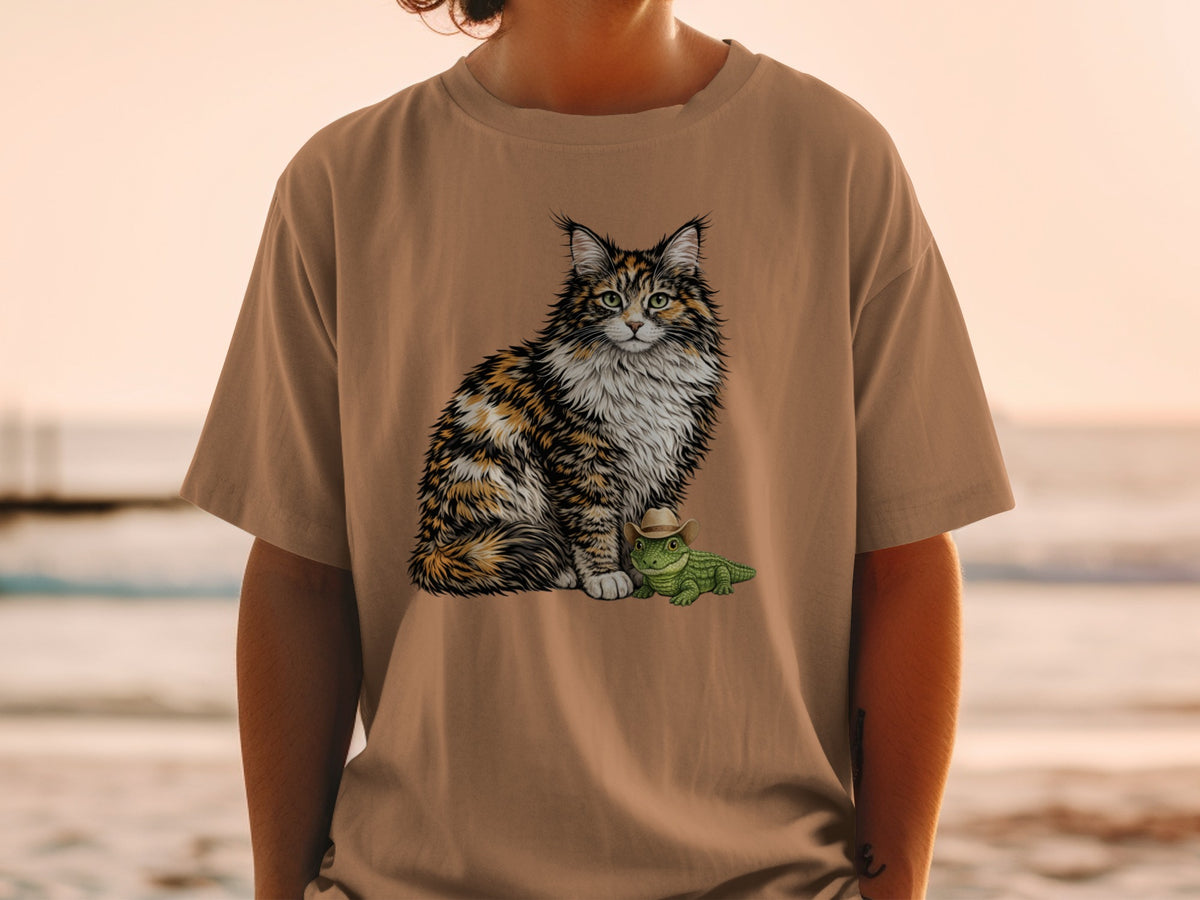 A person wearing a tan t-shirt with an illustration of a fluffy cat and a small alligator wearing a cowboy hat.