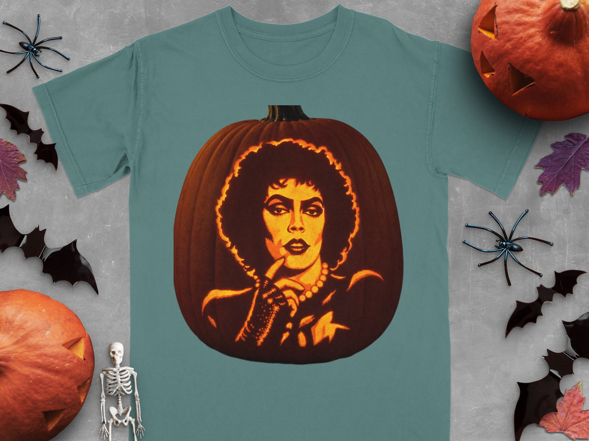 A teal short-sleeve t-shirt featuring a carved pumpkin graphic of Frank-N-Furter, surrounded by Halloween decorations.