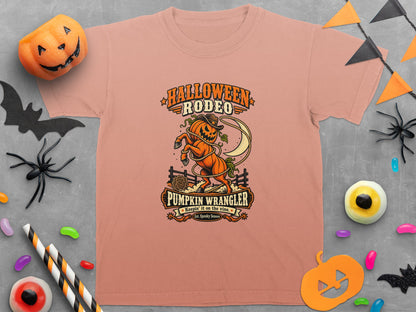 Peach t-shirt with "Halloween Rodeo Pumpkin Wrangler" text and pumpkin cowboy graphic.