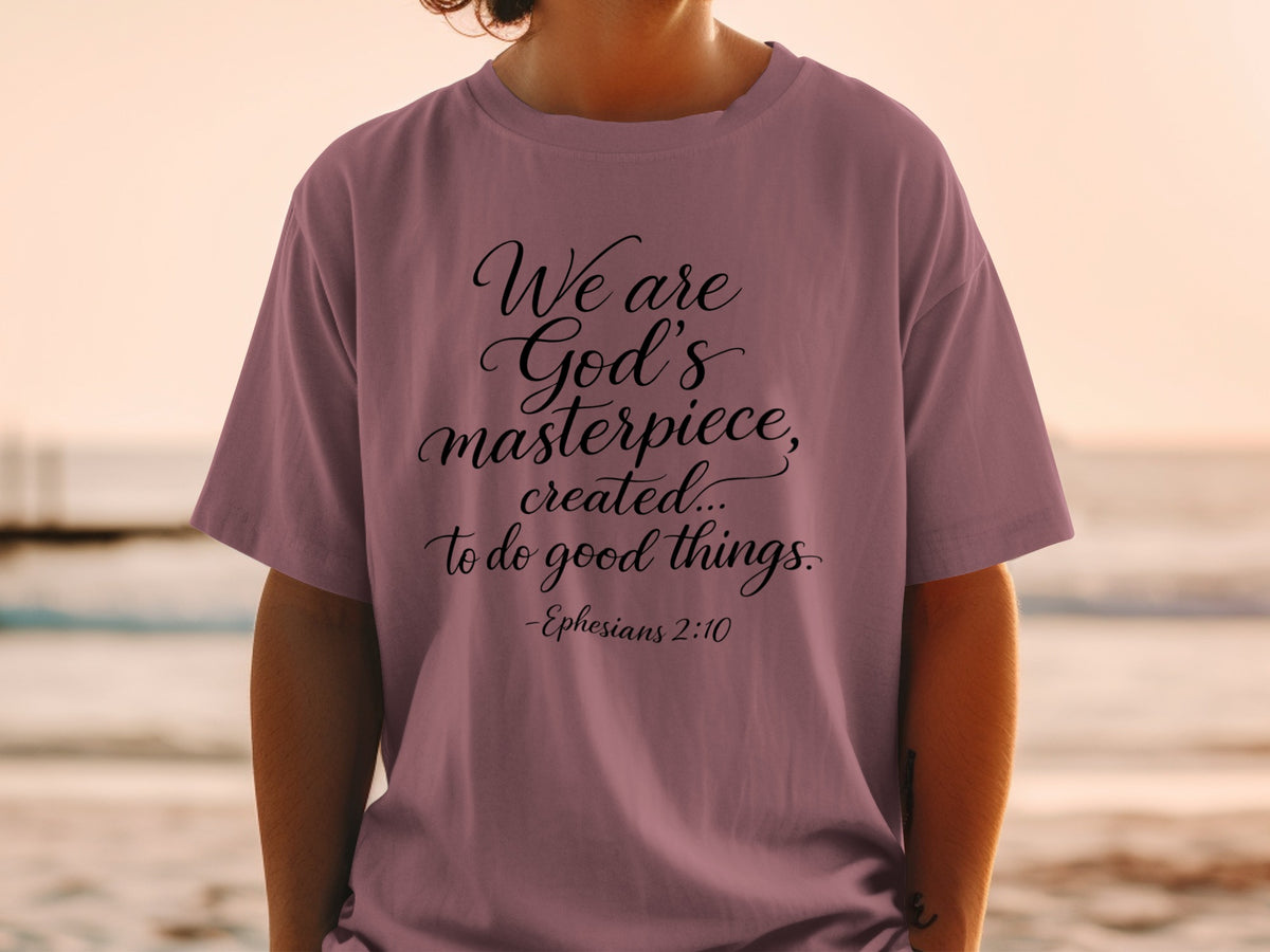 Mauve t-shirt with black text: "We are God's masterpiece, created... to do good things. -Ephesians 2:10"
