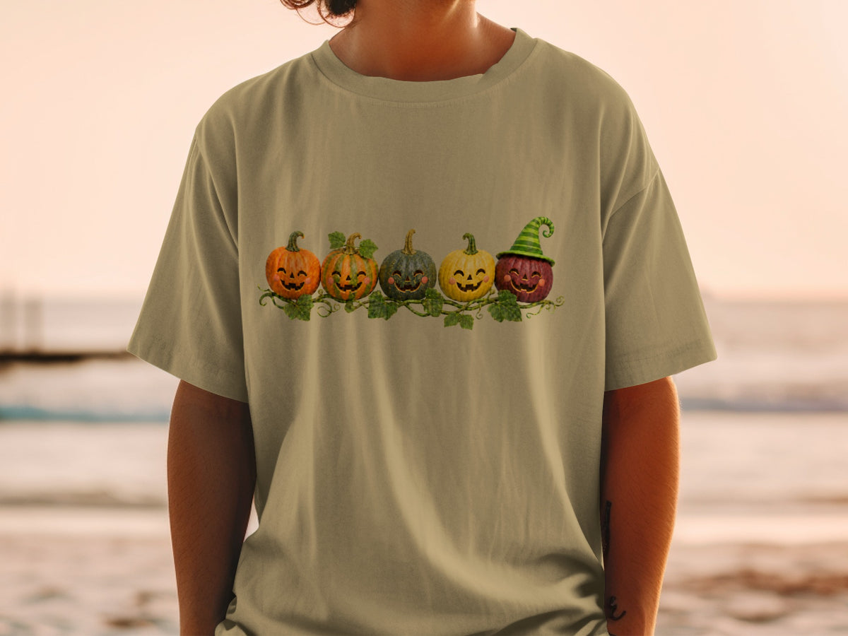 T-shirt with a row of five carved pumpkins with happy faces and vines.
