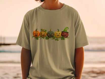 T-shirt with a row of five carved pumpkins with happy faces and vines.