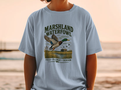 T-shirt graphic with marshland waterfowl, a flying duck, and text.