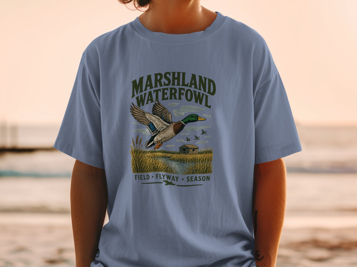 T-shirt graphic with mallard duck flying over marshland, text "MARSHLAND WATERFOWL".