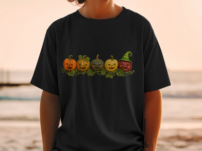 Black t-shirt featuring a line of five smiling, carved pumpkins.