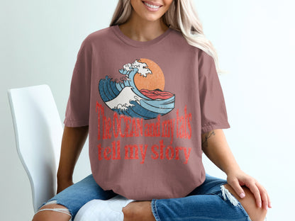 Brown t-shirt with a distressed wave graphic and text "The OCEAN and my tails tell my story".