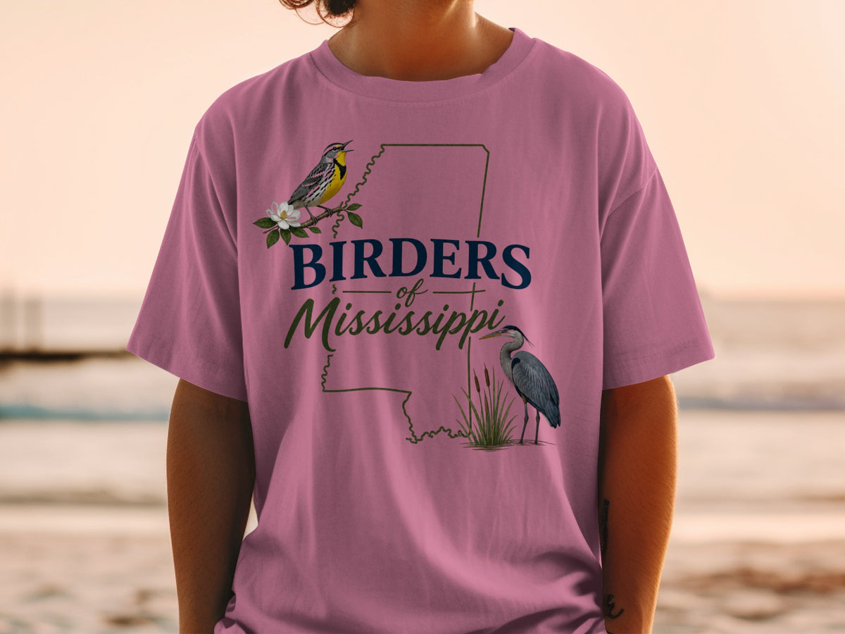 Pink t-shirt with "Birders of Mississippi" text and illustrations of birds and state outline.