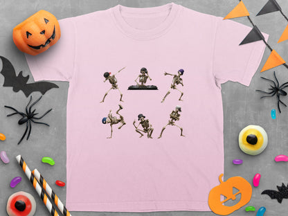 Pink t-shirt with six dancing skeletons graphic, surrounded by Halloween decorations.