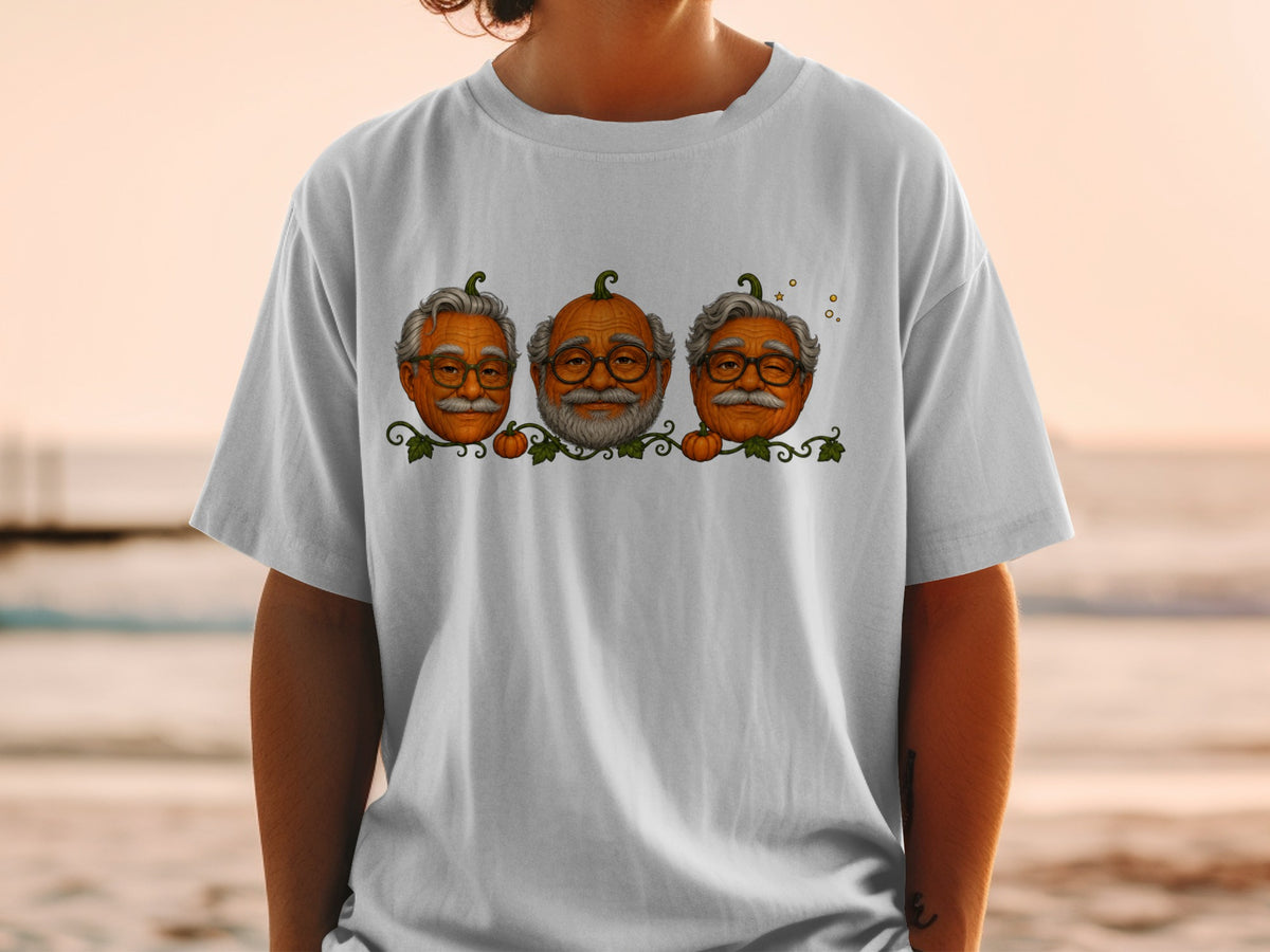 Three pumpkins with elderly men's faces and glasses on a white t-shirt.