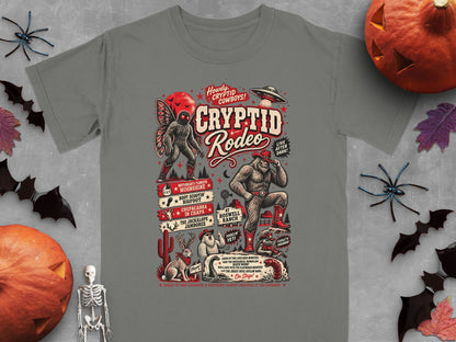 Gray t-shirt with Cryptid Rodeo graphic featuring Bigfoot, Mothman, Chupacabra, and UFO.