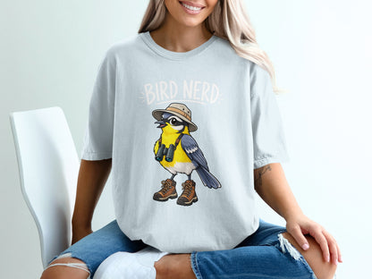 Light blue t-shirt with cartoon bird wearing hat, binoculars, and boots.