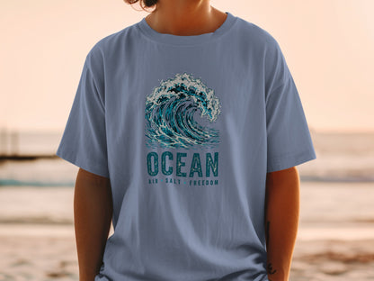 T-shirt with a graphic of a breaking wave and text reading "OCEAN AIR SALT FREEDOM".