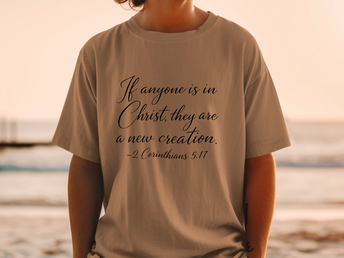 T-shirt with script text: "If anyone is in Christ, they are a new creation. -2 Corinthians 5:17"