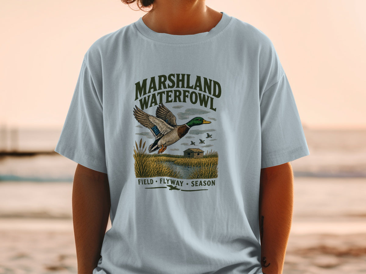 T-shirt graphic with mallard duck in flight over marshland, reading "MARSHLAND WATERFOWL".