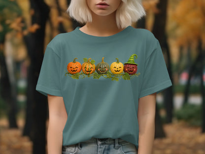 Teal t-shirt with a row of five happy, carved pumpkins and green vines.