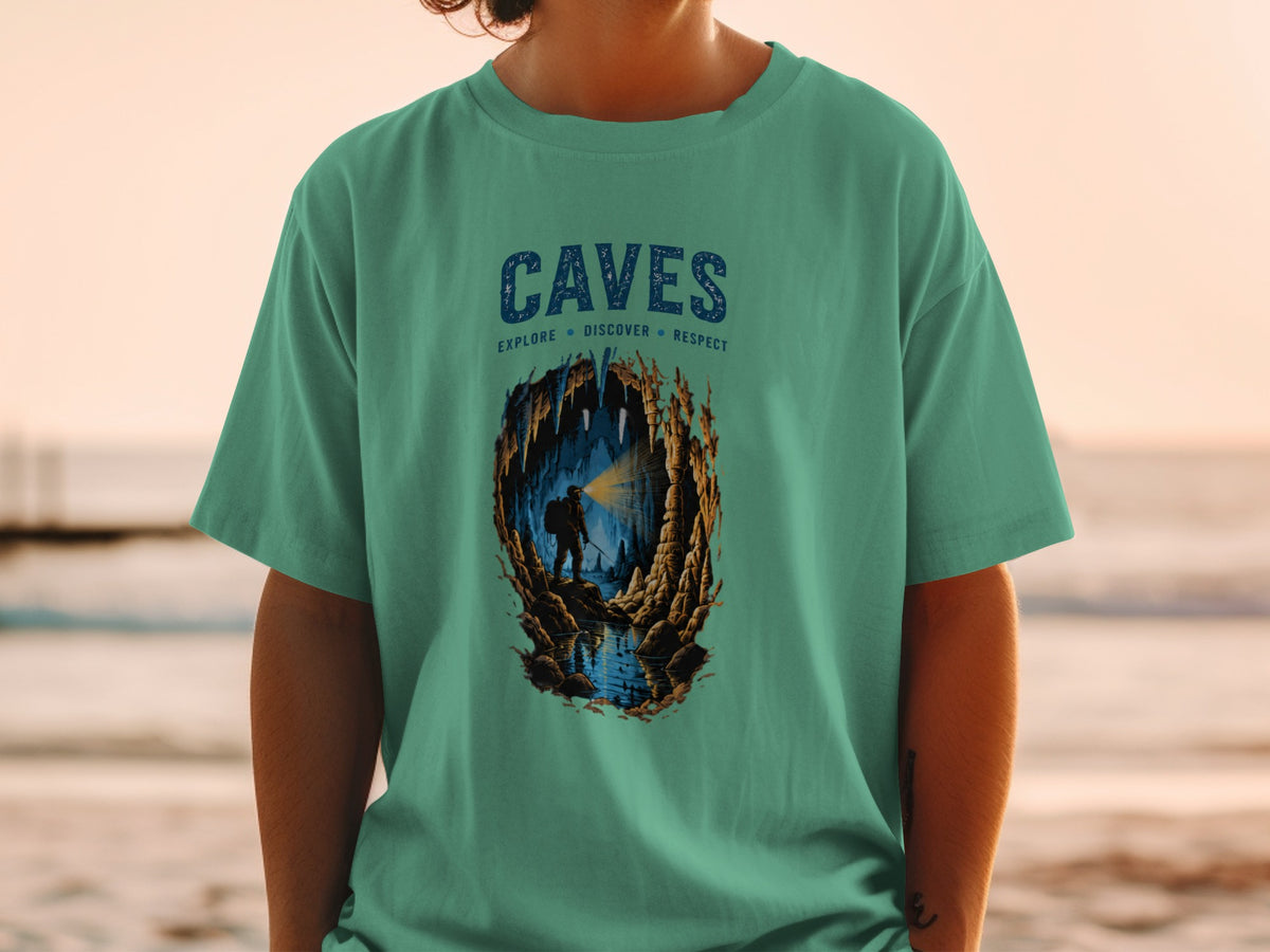 Green t-shirt with "CAVES" text and illustration of a caver exploring a cave.