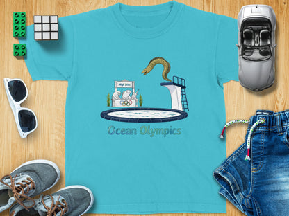 Turquoise t-shirt graphic with an eel diving into a pool, "Ocean Olympics" text.