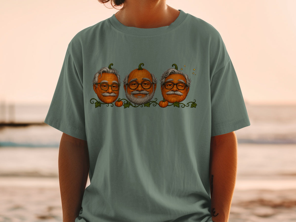 Three pumpkins with elderly men's faces and glasses on a grey t-shirt.