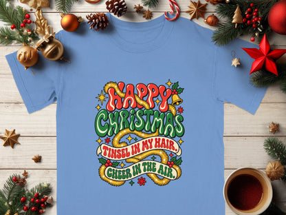 Light blue t-shirt with "Happy Christmas" and "Tinsel in my hair, cheer in the air" text.
