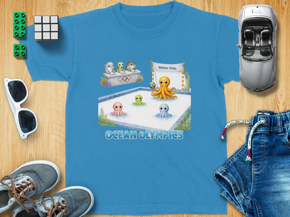 Blue t-shirt with "Ocean Olympics" text and cartoon sea creatures playing water polo.