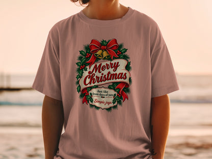 T-shirt with Merry Christmas text, wreath, bow, and bells graphic.