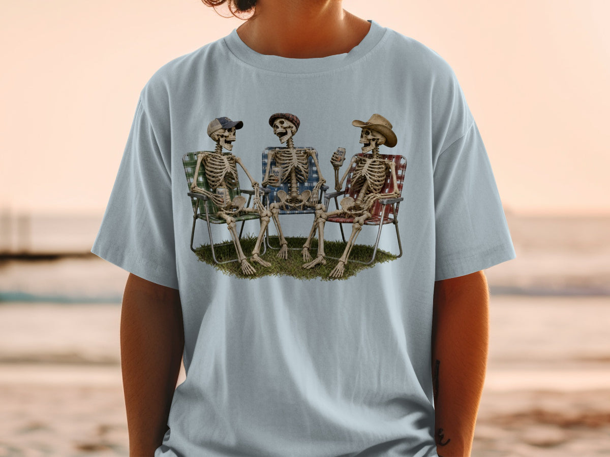 Three skeletons in lawn chairs holding drinks with a sunset beach background.
